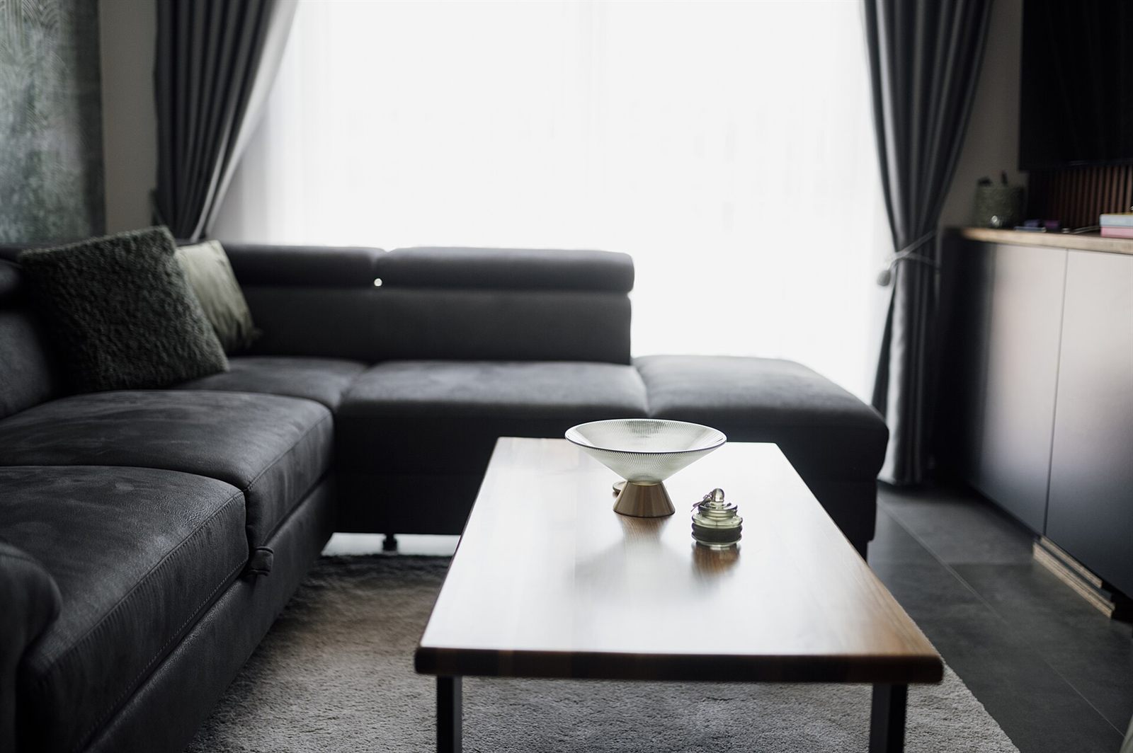 A bright planned living room with a gray sofa by the window
